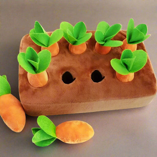 Plush toy resembling a garden with carrots and green leaves on a white background